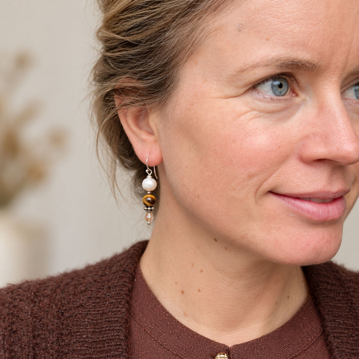oorbellen edelsteen tijgeroog, zoetwaterparels en Swarovski te zien bij een model